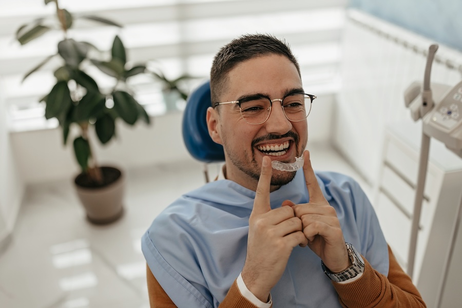 Man wearing invisalign trays in dental chair